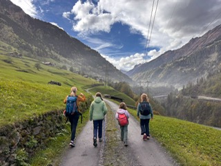 Family walking in a green mountain valley